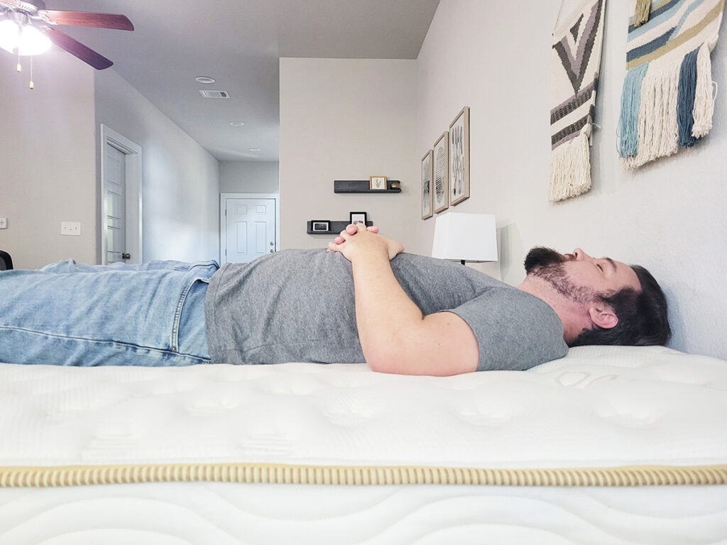 man sleeping on his back on the Saatva mattress