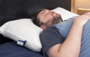 A man sleeps on his back using the Down Dreams pillow.