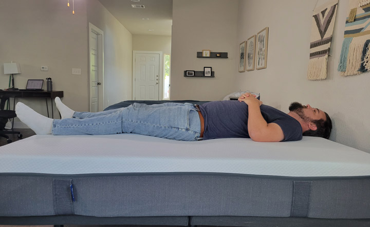 A man sleeps on his back on the Emma CliMax mattress