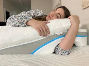 A woman rests with the MedCline Shoulder relief system