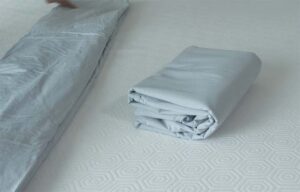 The Best Percale Sheets - an image of gray sheets folded up on a bed.