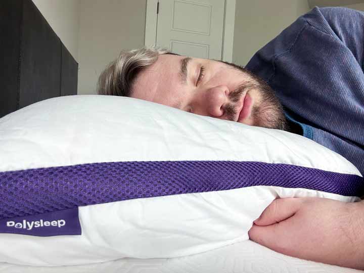 A man sleeps on his side with the Polysleep pillow.