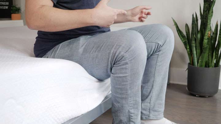 man sitting on the edge of the Puffy mattress