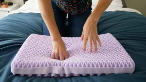 A man presses into the Purple Pillow without its cover on.