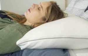 A woman sleeps on her back with the Sleep Number True Temp pillow