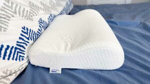 The TEMPUR-Neck Pillow on a bed.