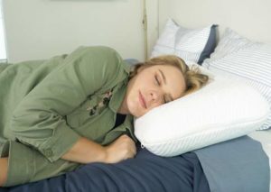 The Best Firm Pillows - A woman sleeps on her side with the Tuft & Needle foam pillow